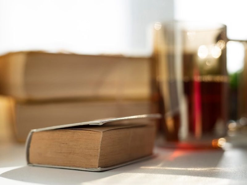 Livros antigos de capa dura sobre uma mesa de madeira